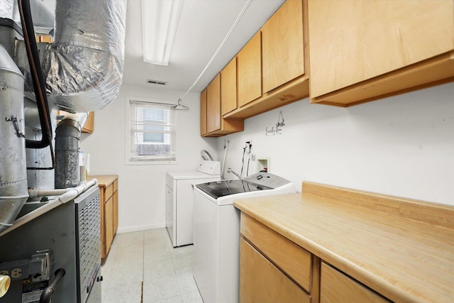 laundry area with washing machine and clothes dryer, visible vents, cabinet space, and baseboards