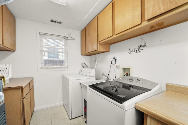 laundry area featuring visible vents, baseboards, light tile patterned floors, cabinet space, and separate washer and dryer