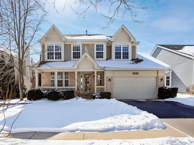 view of front of home featuring covered porch, brick siding, and driveway