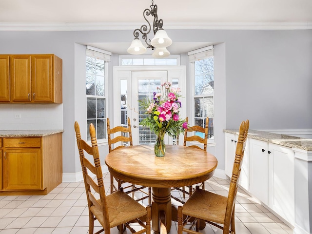 dining area with ornamental molding, baseboards, and light tile patterned floors