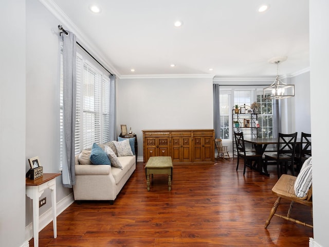 living area with ornamental molding, recessed lighting, dark wood finished floors, and an inviting chandelier