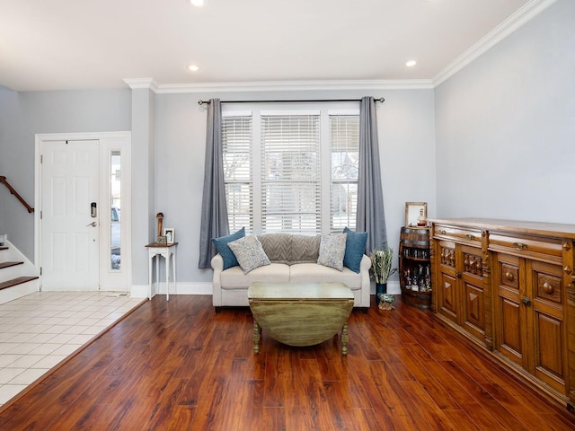 sitting room with ornamental molding, stairway, and wood finished floors