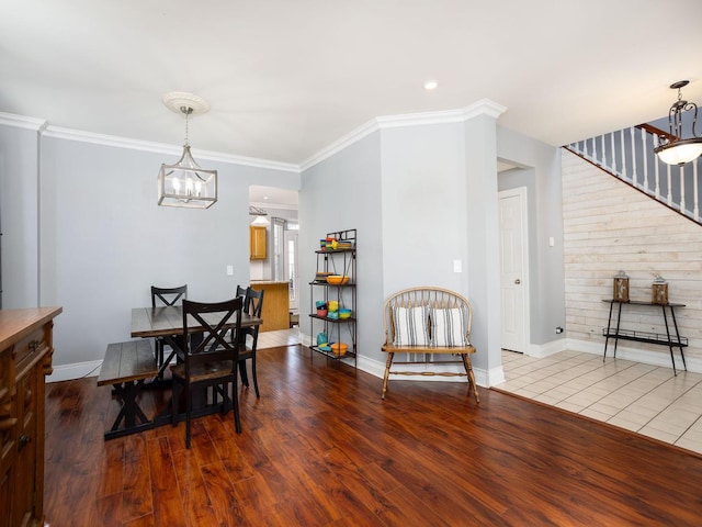 dining space with baseboards, crown molding, a chandelier, and wood finished floors