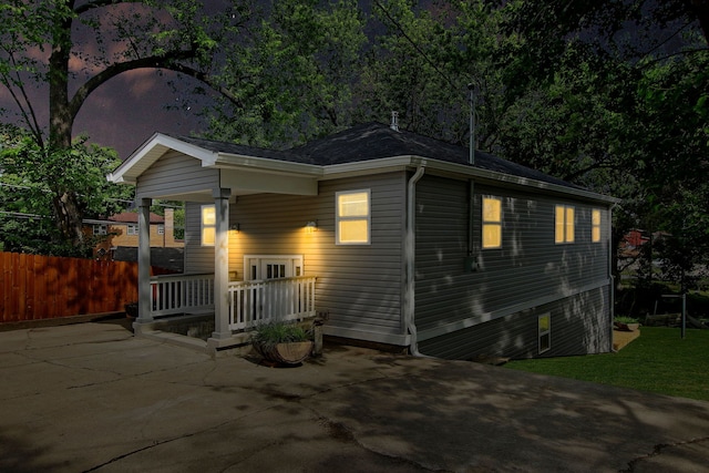 view of front of property featuring a front yard, covered porch, and fence