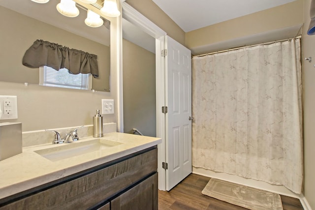 bathroom featuring curtained shower, wood finished floors, and vanity