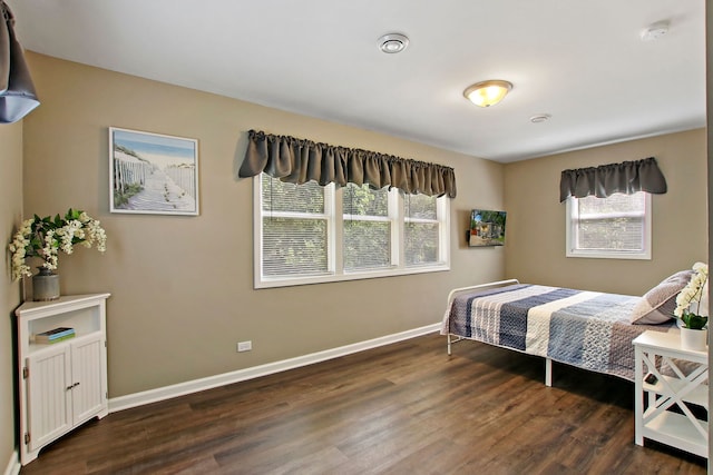 bedroom featuring baseboards and dark wood finished floors