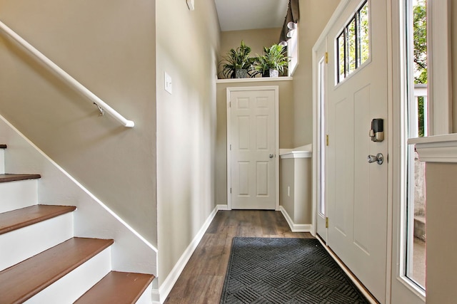 doorway with dark wood-style floors, stairway, and baseboards