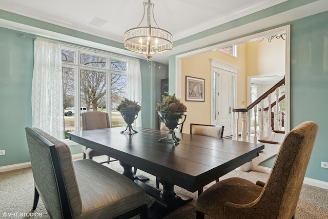 carpeted dining space with visible vents, crown molding, baseboards, stairway, and an inviting chandelier
