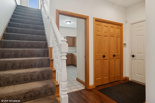foyer with baseboards, stairs, and wood finished floors
