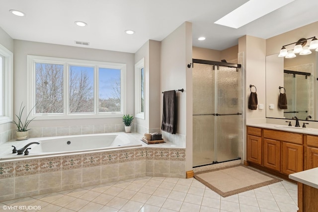 bathroom featuring a shower stall, visible vents, a skylight, and vanity