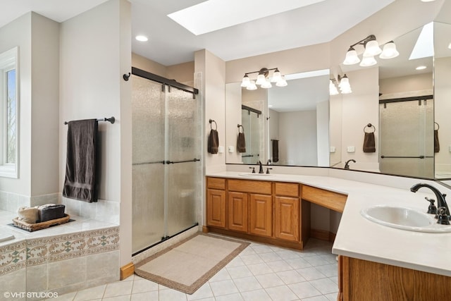full bathroom with a stall shower, a skylight, and a sink