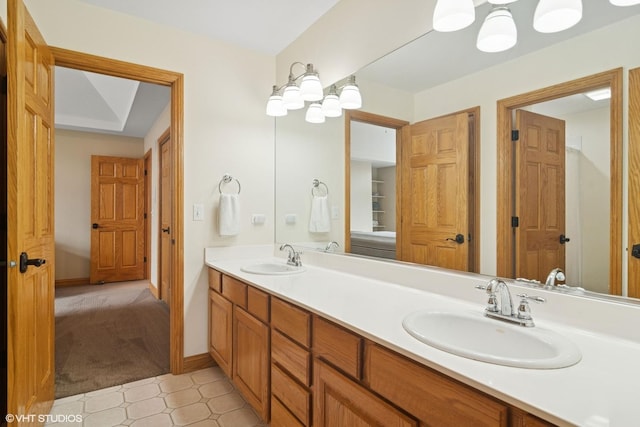 bathroom featuring double vanity, a sink, and baseboards