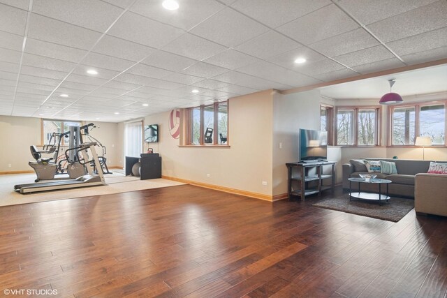 workout area featuring baseboards, wood finished floors, recessed lighting, and a drop ceiling