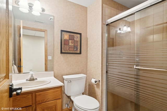 bathroom featuring toilet, wallpapered walls, vanity, a shower stall, and visible vents