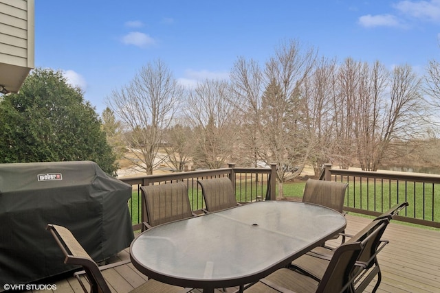 wooden terrace with grilling area, a lawn, and outdoor dining space