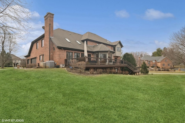 rear view of property with a lawn, a chimney, central air condition unit, and a deck