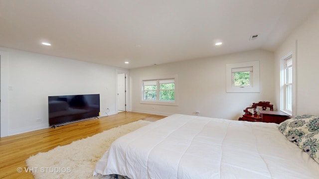 bedroom featuring baseboards, wood finished floors, visible vents, and recessed lighting