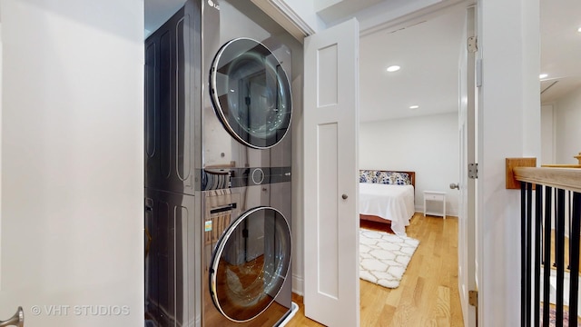 laundry area with stacked washer and dryer, recessed lighting, laundry area, and light wood-style floors