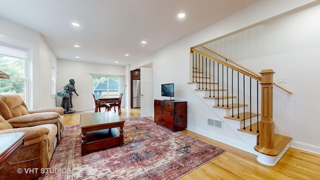 living area featuring light wood finished floors, stairway, visible vents, and recessed lighting