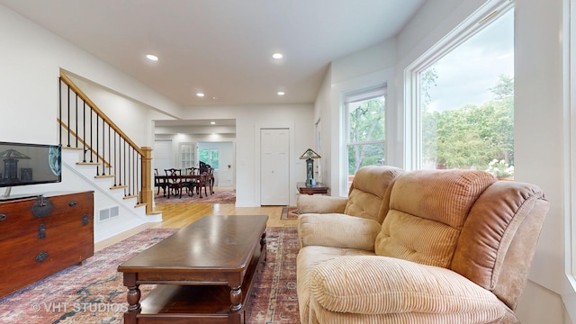 living room featuring stairway, wood finished floors, visible vents, and recessed lighting