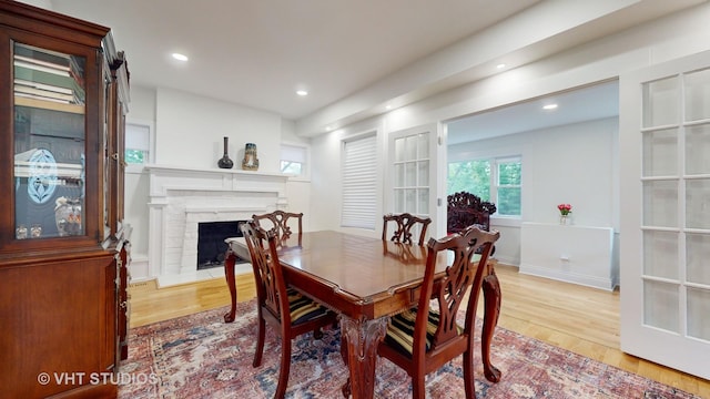 dining area with recessed lighting, a fireplace, and wood finished floors