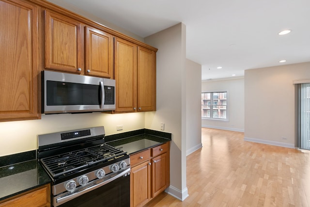 kitchen featuring brown cabinets, recessed lighting, appliances with stainless steel finishes, light wood-type flooring, and baseboards