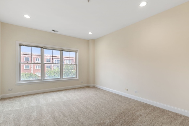 unfurnished room with carpet, baseboards, and visible vents