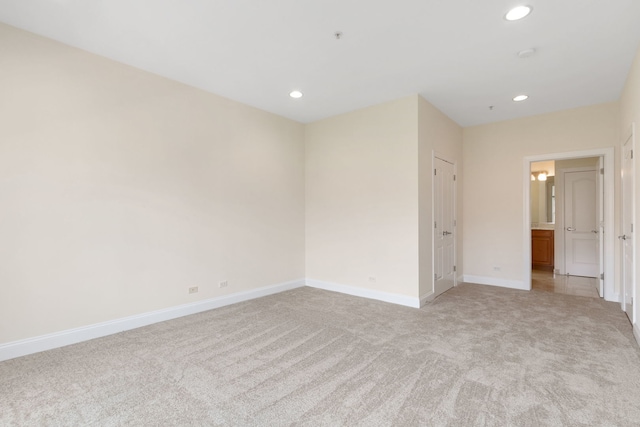 unfurnished room featuring baseboards, recessed lighting, and light colored carpet