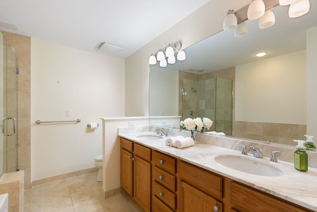 full bathroom featuring a sink, a shower stall, toilet, and double vanity