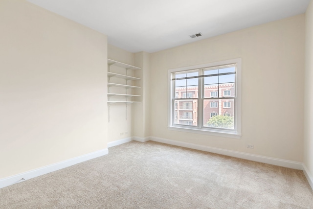 carpeted empty room with visible vents and baseboards