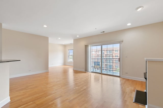 unfurnished living room with baseboards and light wood-style floors