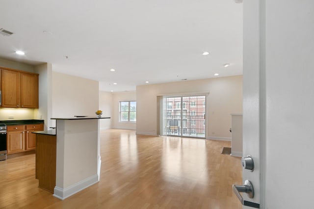 kitchen with dark countertops, light wood finished floors, and recessed lighting