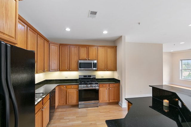 kitchen with dark countertops, recessed lighting, visible vents, light wood-style flooring, and black appliances