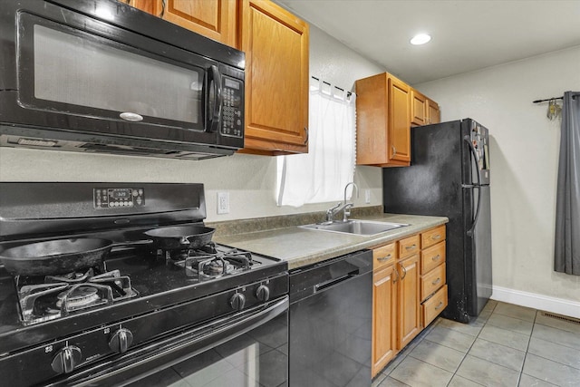 kitchen with visible vents, baseboards, light tile patterned flooring, black appliances, and a sink