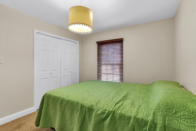 bedroom featuring a closet, baseboards, and carpet floors