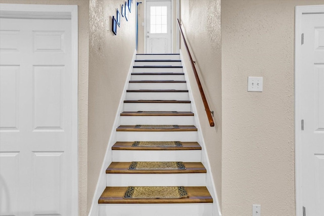 staircase featuring a textured wall