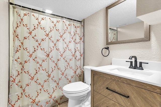 full bathroom featuring a shower with curtain, toilet, a textured ceiling, vanity, and a textured wall