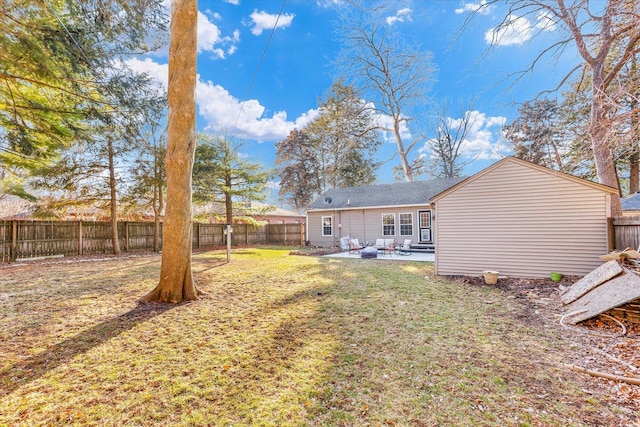 rear view of house with a fenced backyard, a yard, and a patio