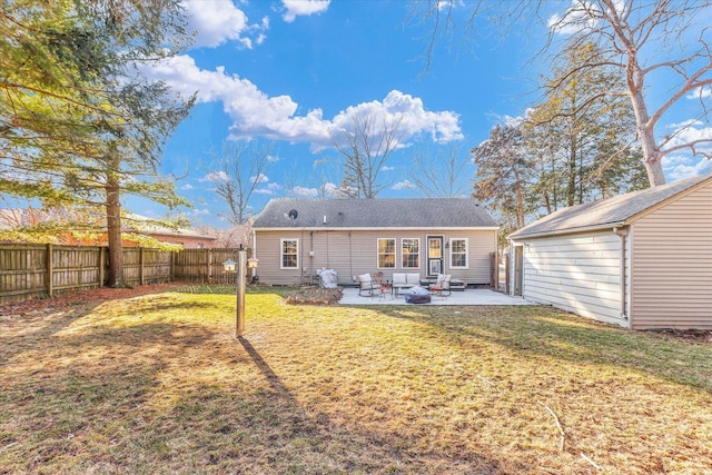 rear view of house featuring a patio, a fenced backyard, a lawn, and an outbuilding