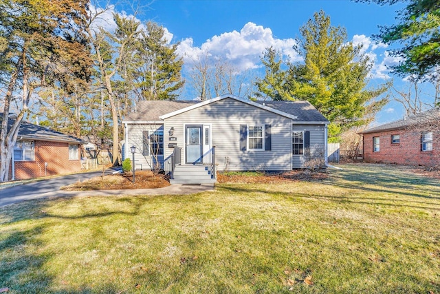 view of front of property featuring aphalt driveway and a front lawn