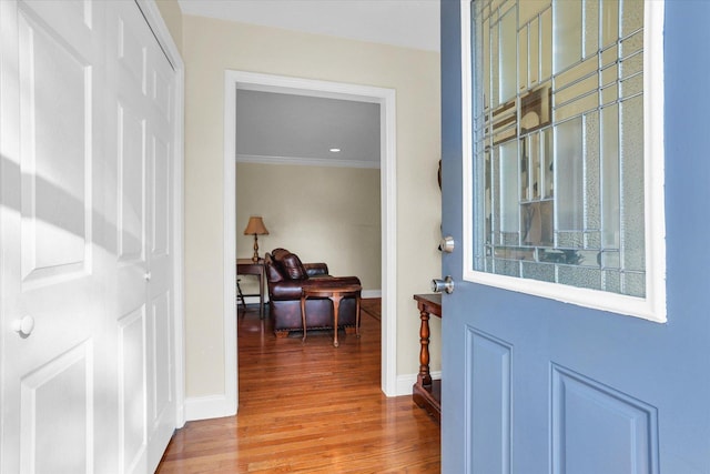 interior space with baseboards, wood finished floors, and ornamental molding