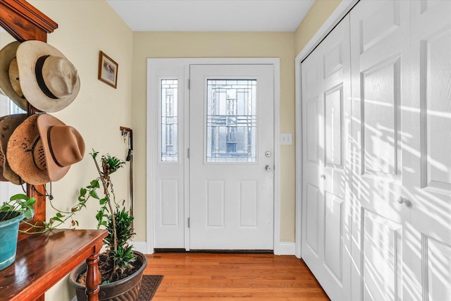 entryway with light wood finished floors and baseboards