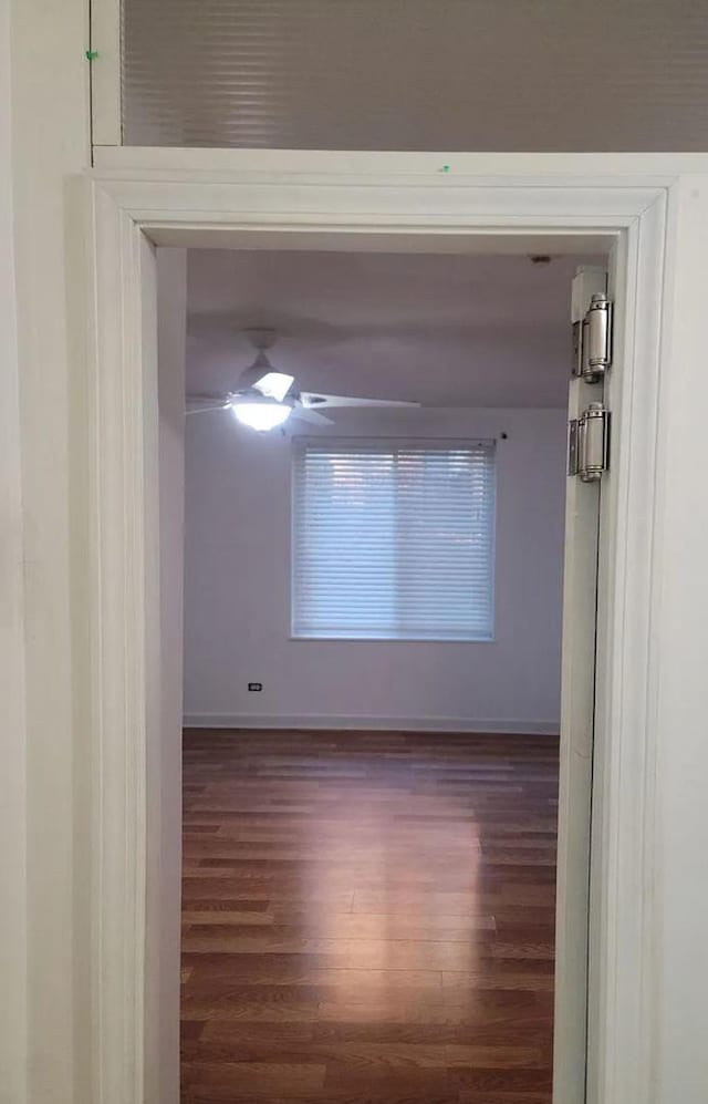 unfurnished room featuring ceiling fan, baseboards, and wood finished floors