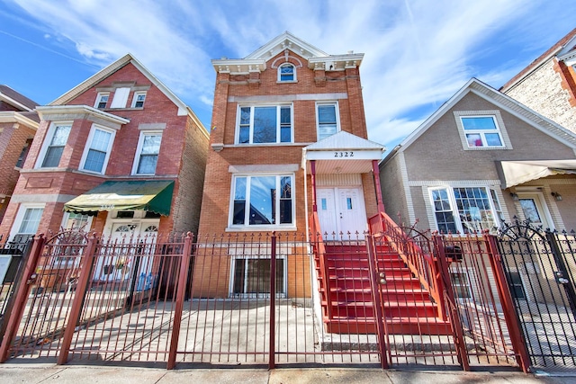 view of front of home featuring a fenced front yard and brick siding