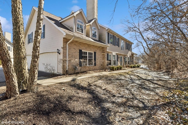 view of side of property with a chimney and brick siding