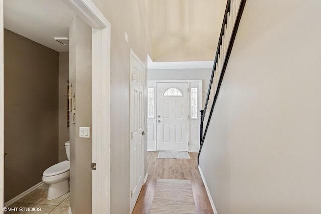 interior space with stairway, light tile patterned floors, and baseboards