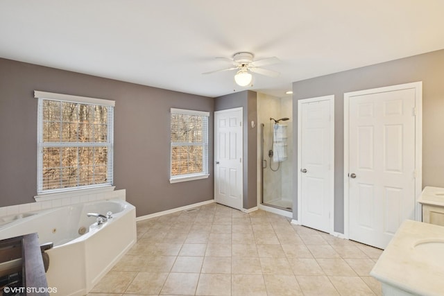 bathroom with ceiling fan, vanity, a jetted tub, tile patterned floors, and a stall shower