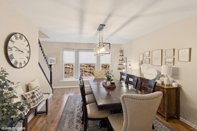 dining area with stairway, wood finished floors, and baseboards