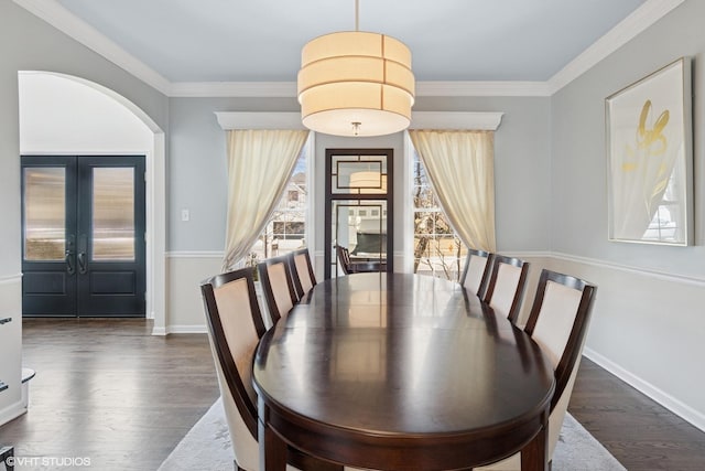 dining space featuring a healthy amount of sunlight, ornamental molding, and dark wood-style flooring