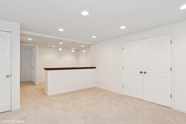 empty room featuring recessed lighting, baseboards, and light colored carpet